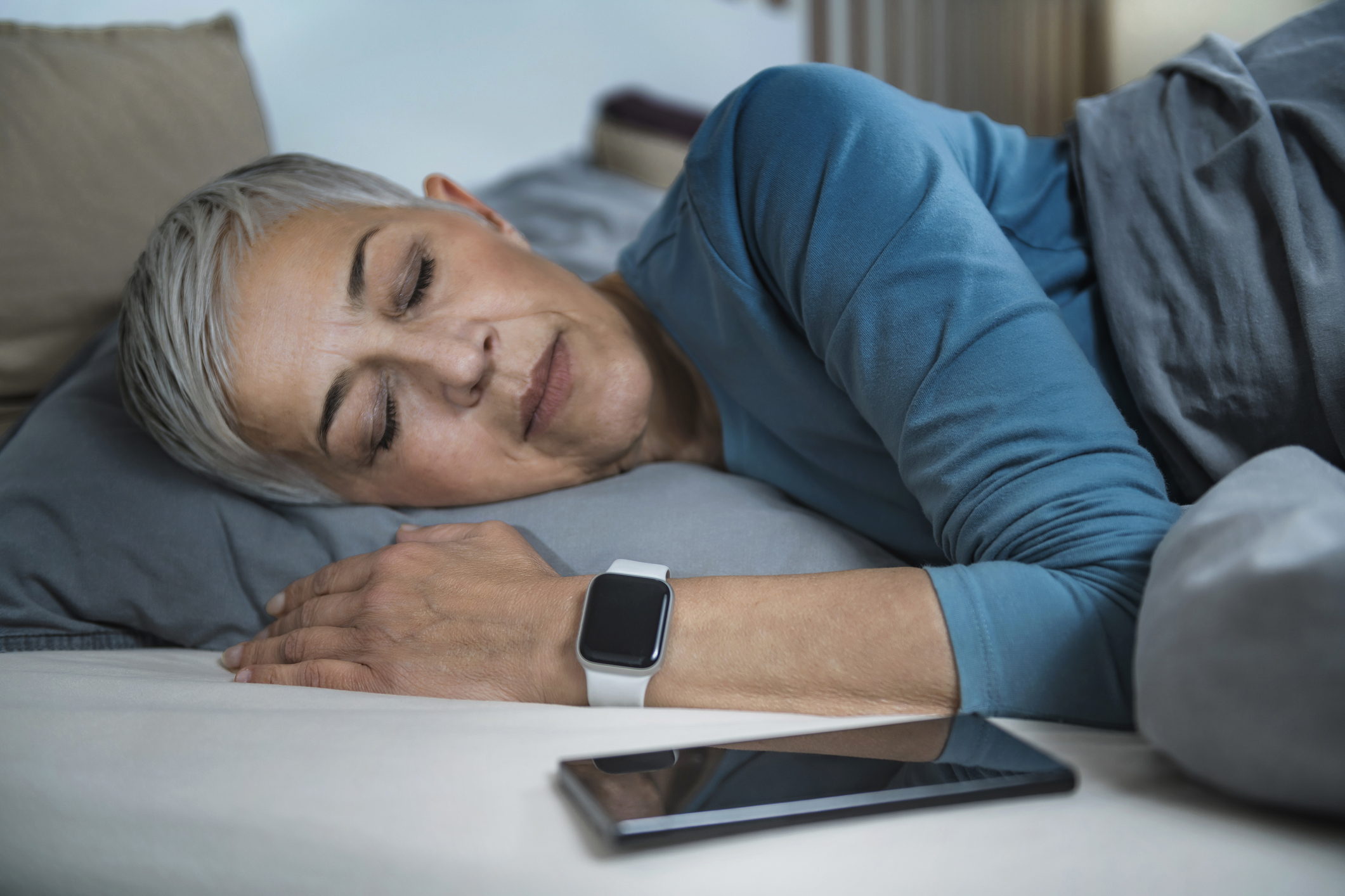 Old woman using a sleep app to help her sleep soundly